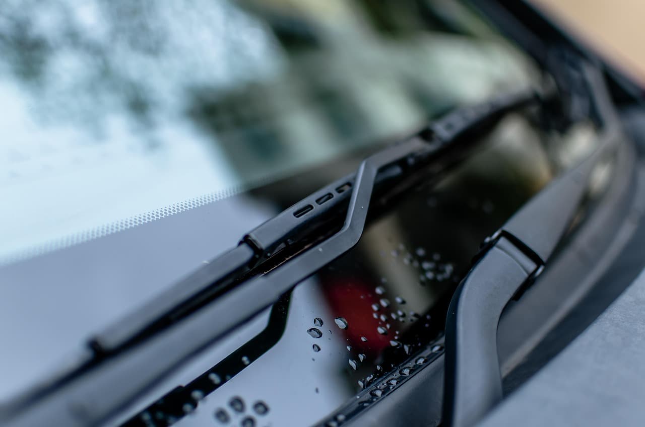 A windscreen wiper blade resting on a wet windscreen